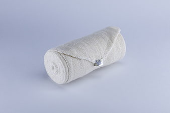 Rolled white medical gauze bandage on white background
