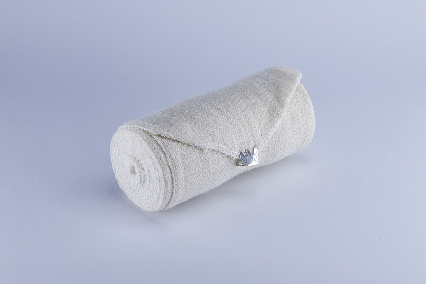Rolled white medical gauze bandage on white background