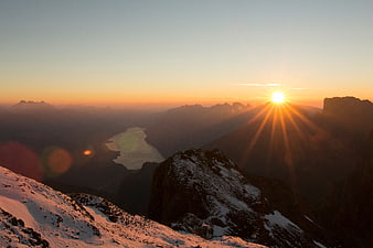 Sunset Over Snowy Mountain Peaks and Distant Lake