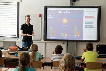 Teacher presenting interactive feedback dashboard to elementary students in classroom