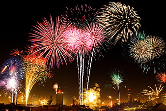Colorful fireworks exploding over city skyline at night