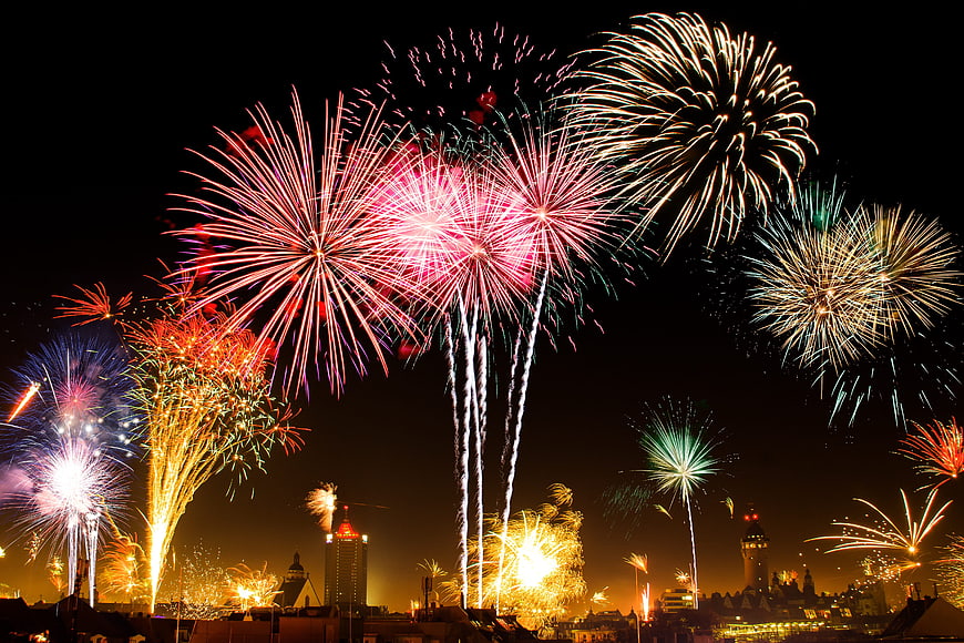 Colorful fireworks exploding over city skyline at night