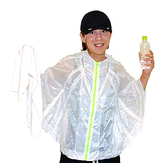 Woman in silver rain poncho holding water bottle and towel