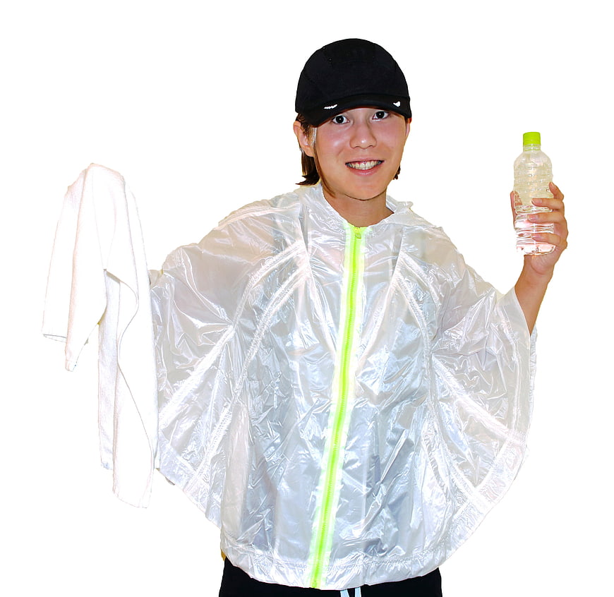 Woman in silver rain poncho holding water bottle and towel