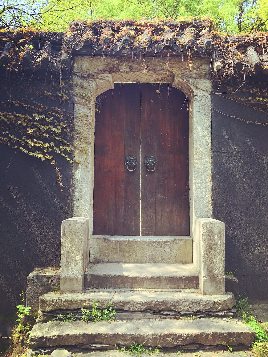 Ancient wooden door with stone steps and ivy