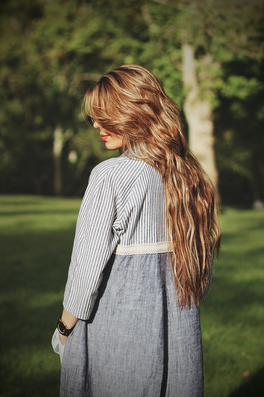 Woman with Long Wavy Hair in Striped Dress Outdoors