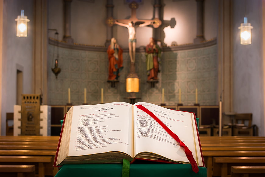 Open Bible with Red Bookmark in Church Interior