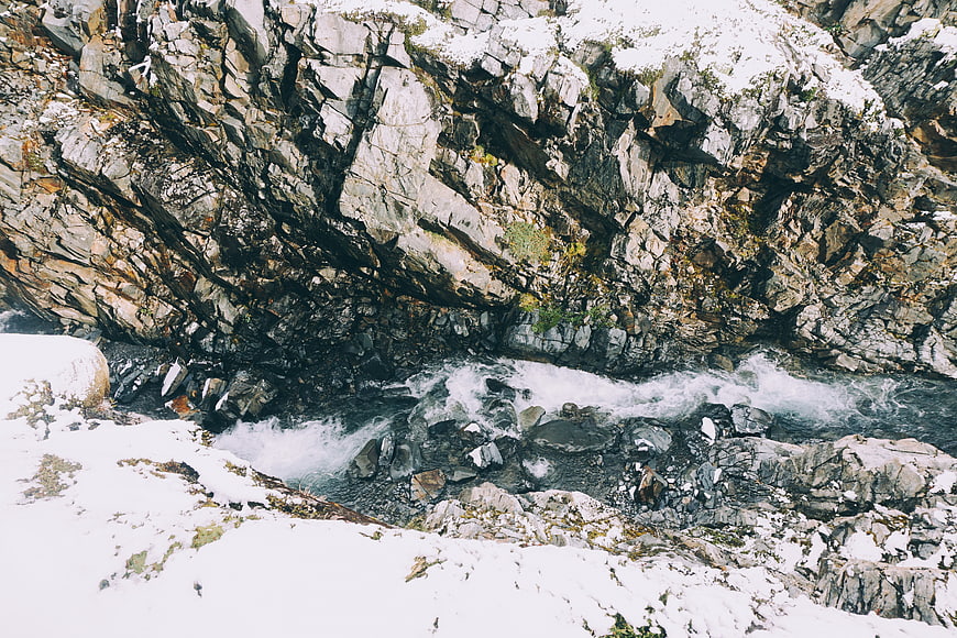 Snowy Mountain Stream Flowing Through Rocky Canyon