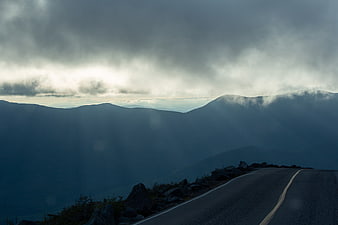 Winding Mountain Road Through Misty Clouds and Fog