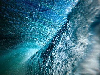 Underwater view of a crashing ocean wave with bubbles