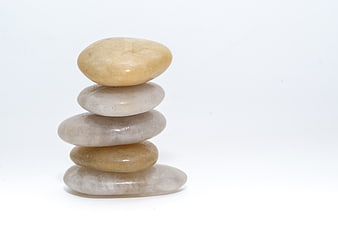 Stacked smooth stones on white background for zen and spa