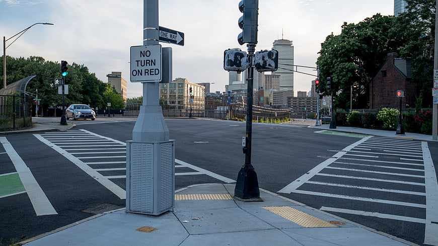 Empty Urban Street Intersection with Traffic Lights and City Skyline