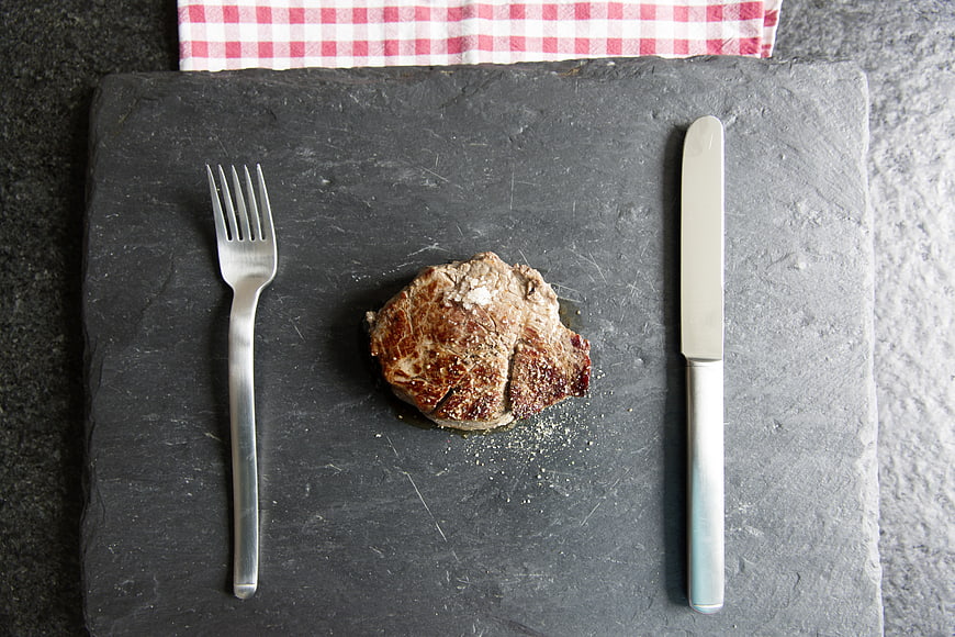 Grilled Steak on Slate Board with Cutlery and Checkered Napkin