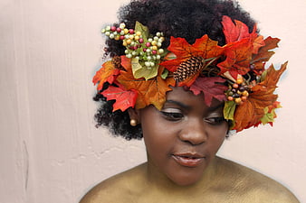 Woman with autumn leaf crown and gold body paint