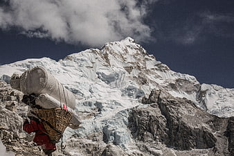 Sherpa porter carrying heavy load in Himalayas