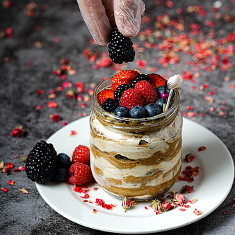 Layered dessert in glass jar topped with fresh berries
