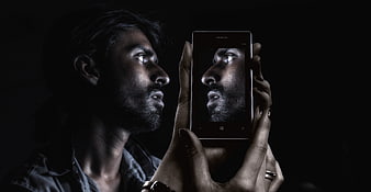 Man holding smartphone with self-portrait on screen