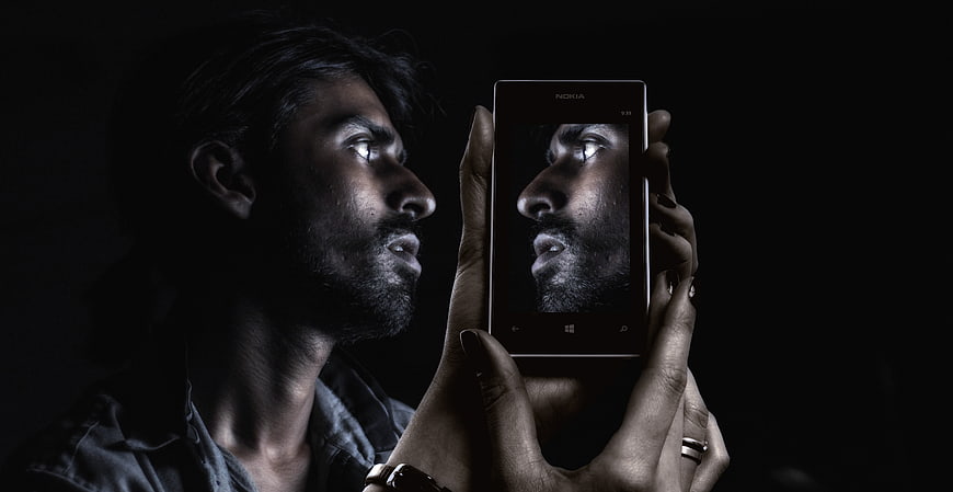 Man holding smartphone with self-portrait on screen