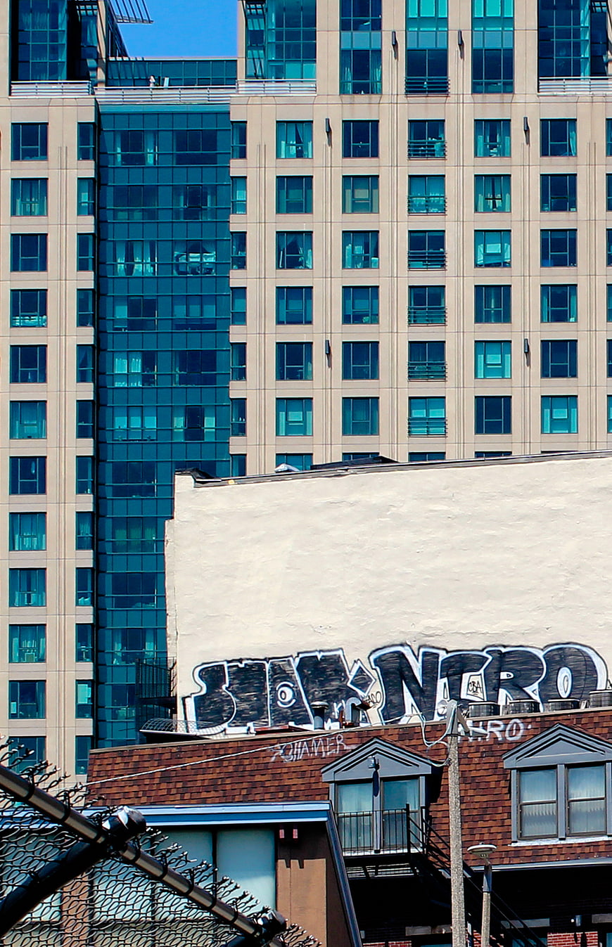 Urban Graffiti on Building Wall with Modern High-Rise Background