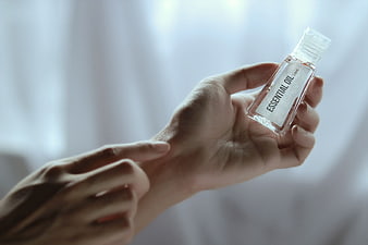 Hand holding essential oil bottle for aromatherapy