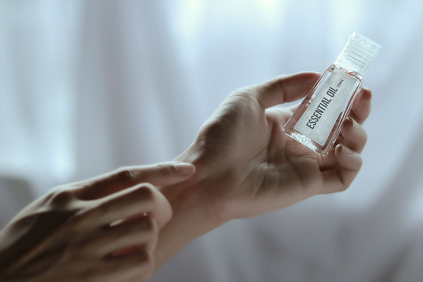 Hand holding essential oil bottle for aromatherapy