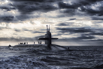 Nuclear submarine surfacing in rough ocean under dramatic cloudy sky