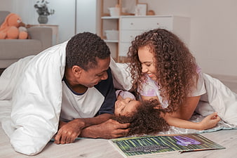 Happy Black Family Reading Together on Floor at Home