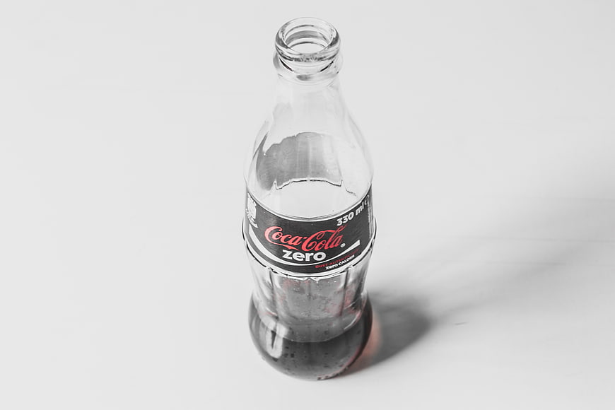 Empty Coca-Cola Zero Glass Bottle on White Background