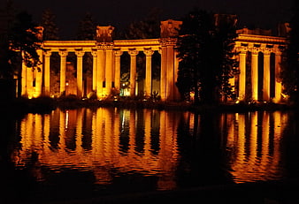 Illuminated Ancient Columns Reflected in Water at Night