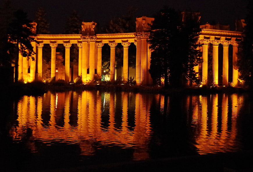 Illuminated Ancient Columns Reflected in Water at Night