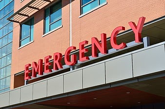 Red Emergency Sign on Modern Hospital Building Exterior