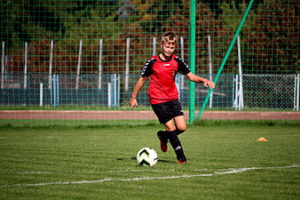 Young boy playing soccer on grass field