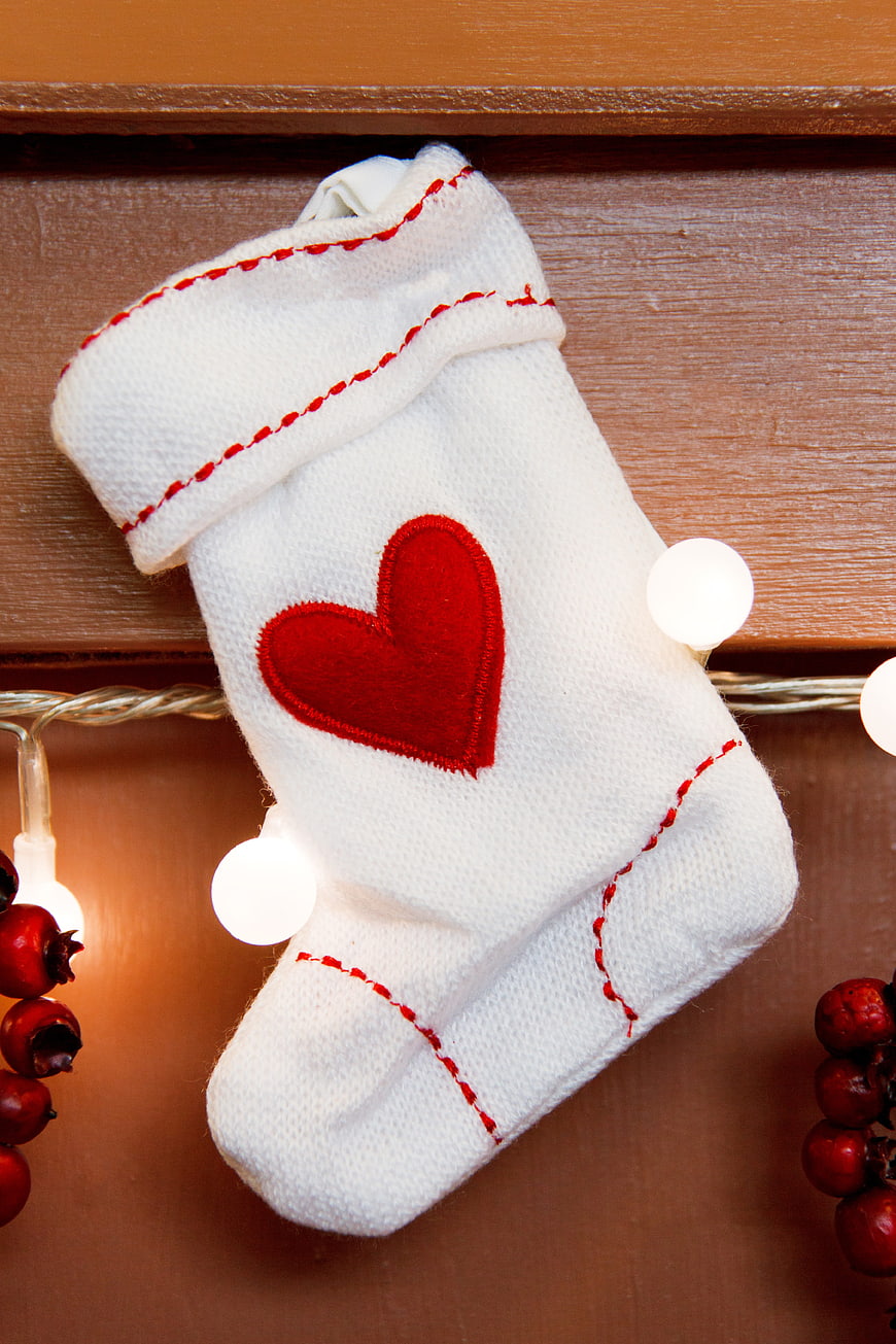 White Christmas Stocking With Red Heart On Wooden Shelf