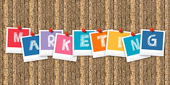 Marketing spelled out on colorful polaroid photos pinned to wood