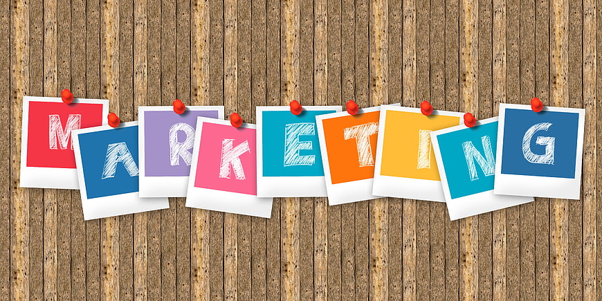 Marketing spelled out on colorful polaroid photos pinned to wood