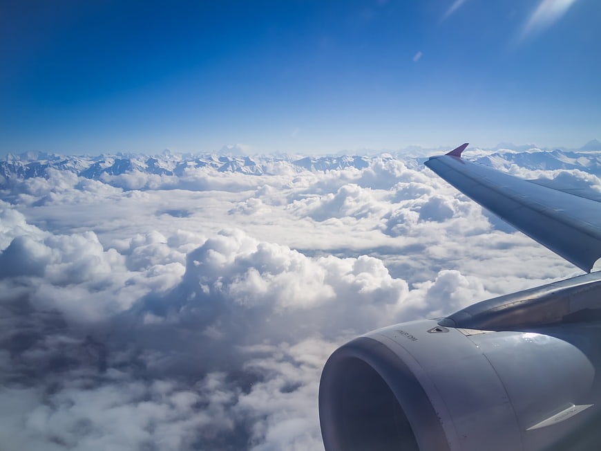 Aerial View of Himalayan Mountains and Clouds from Airplane Window