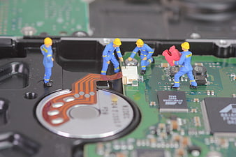 Miniature Workers Repairing Hard Drive Circuit Board