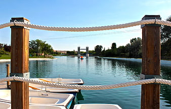 Boats docked at a lake with a miniature Tower Bridge replica