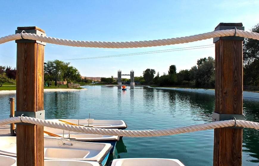 Boats docked at a lake with a miniature Tower Bridge replica