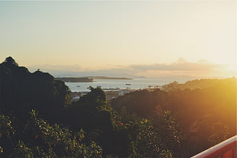 Golden Sunset Over Tropical Coastline with Ocean and Hills