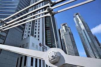 Low angle view of Singapore skyscrapers through bridge railing