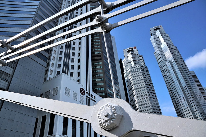 Low angle view of Singapore skyscrapers through bridge railing