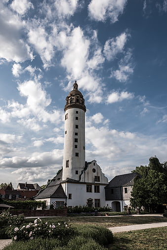 Historic white tower with garden and blue sky