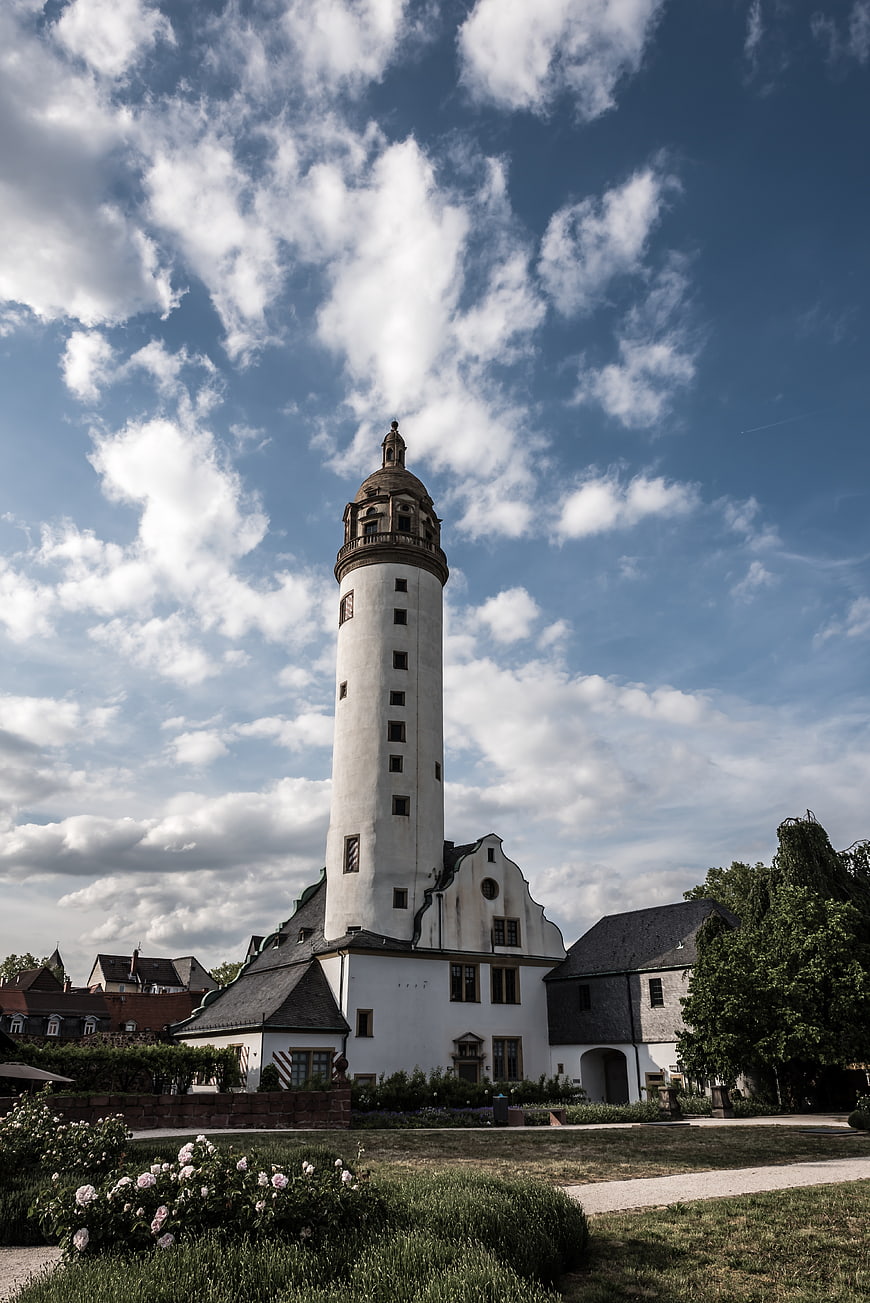 Historic white tower with garden and blue sky