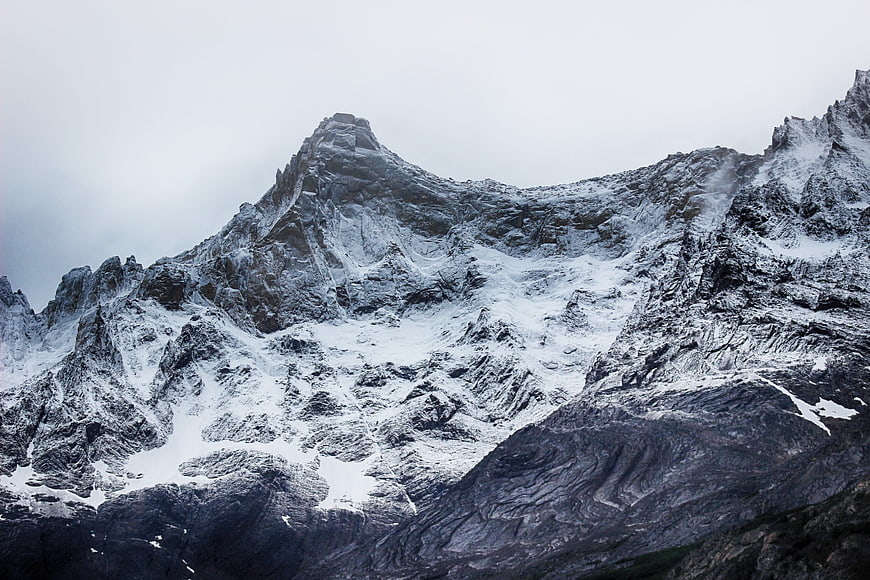 Majestic Snow-Capped Mountain Peak Under Overcast Sky