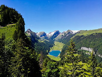 Scenic Alpine Valley with Turquoise Lake and Snowy Peaks