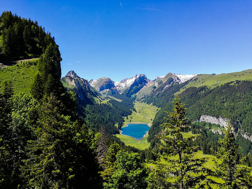 Scenic Alpine Valley with Turquoise Lake and Snowy Peaks