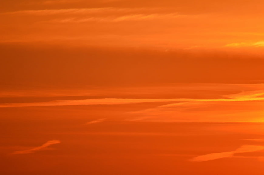 Vibrant Orange Sunset Sky with Streaky Clouds