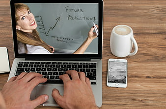 Businessman typing on laptop with online training video of female teacher
