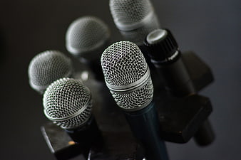 Close-up of multiple silver microphones on stands